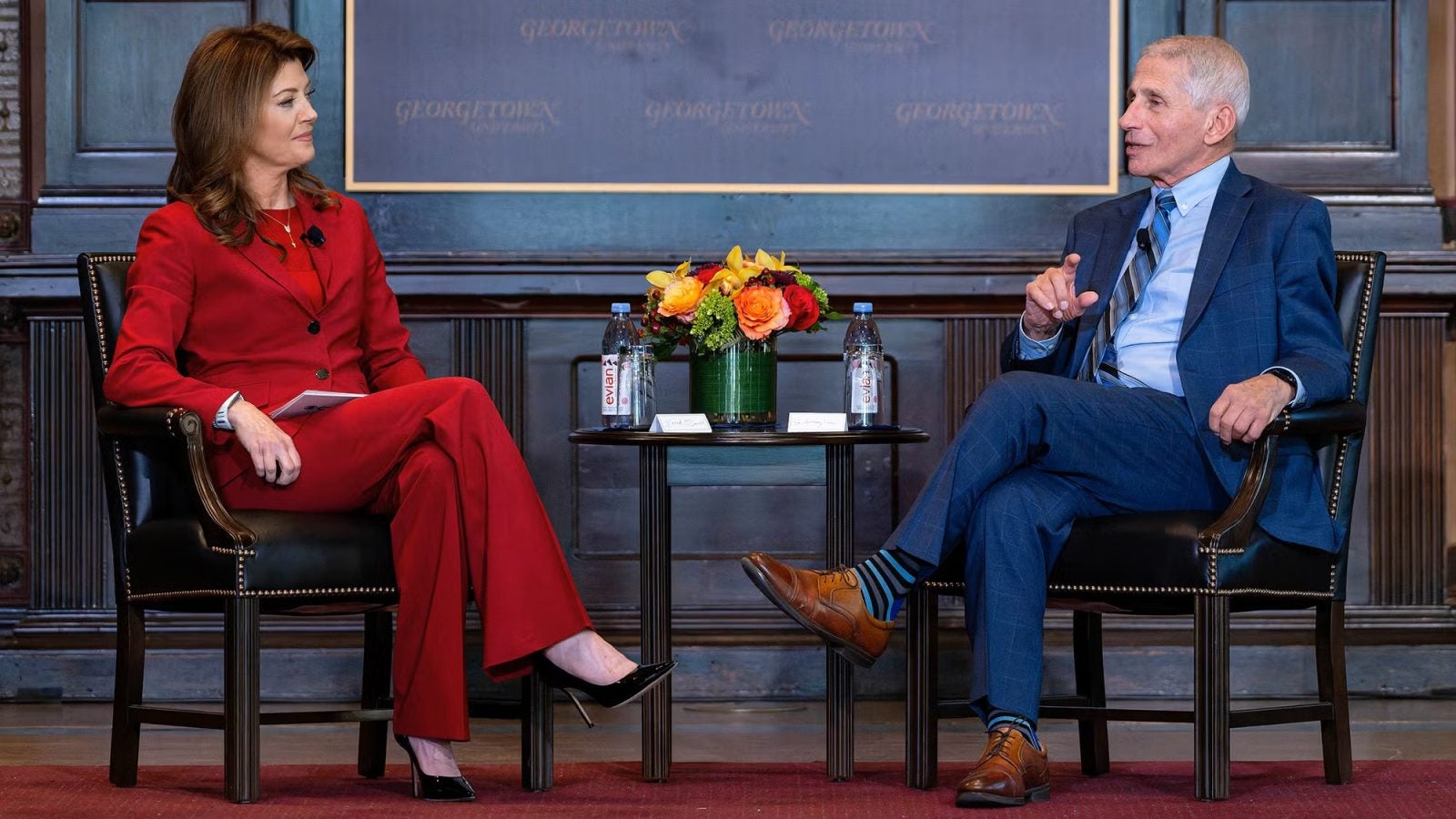 Anthony Fauci in a chair in conversation with Norah O'Donnell