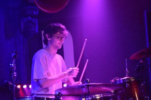 Young man plays drums at a concert