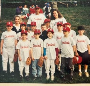 A Little League team in jerseys with coaches