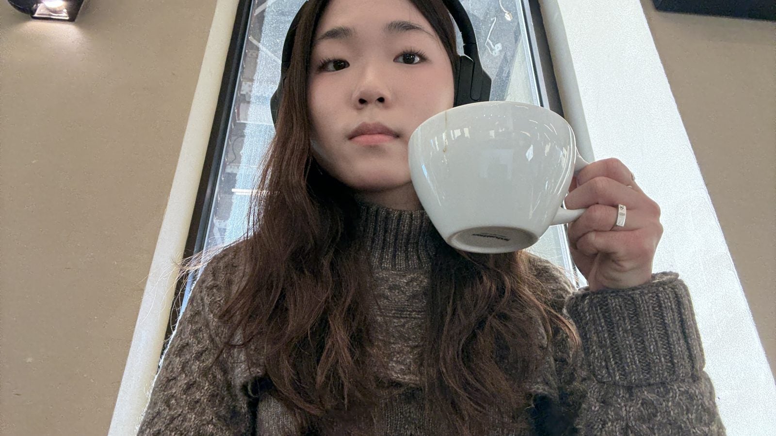 Young Asian woman holding a cup of coffee