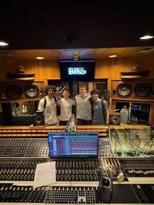 Four young men in a recording studio