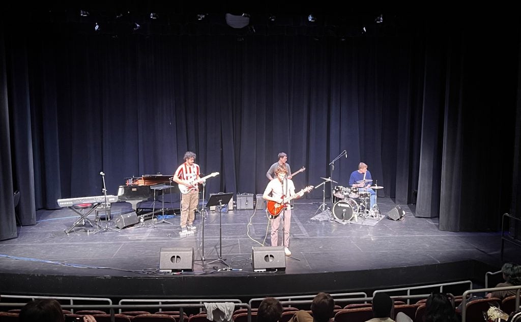 Four young men performing on stage