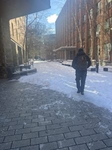 A student walks through a snowy Georgetown campus