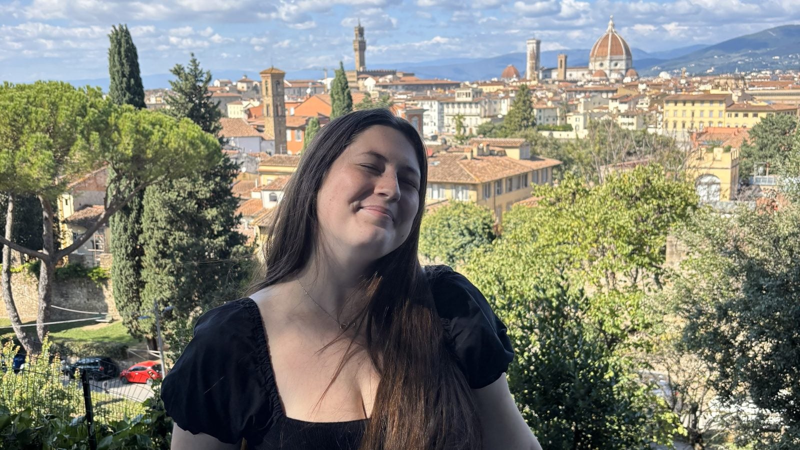 Sydney smiling with an Italian city behind her