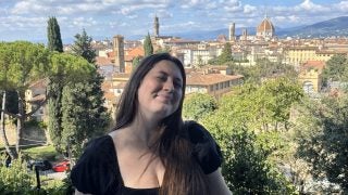 Sydney smiling with an Italian city behind her