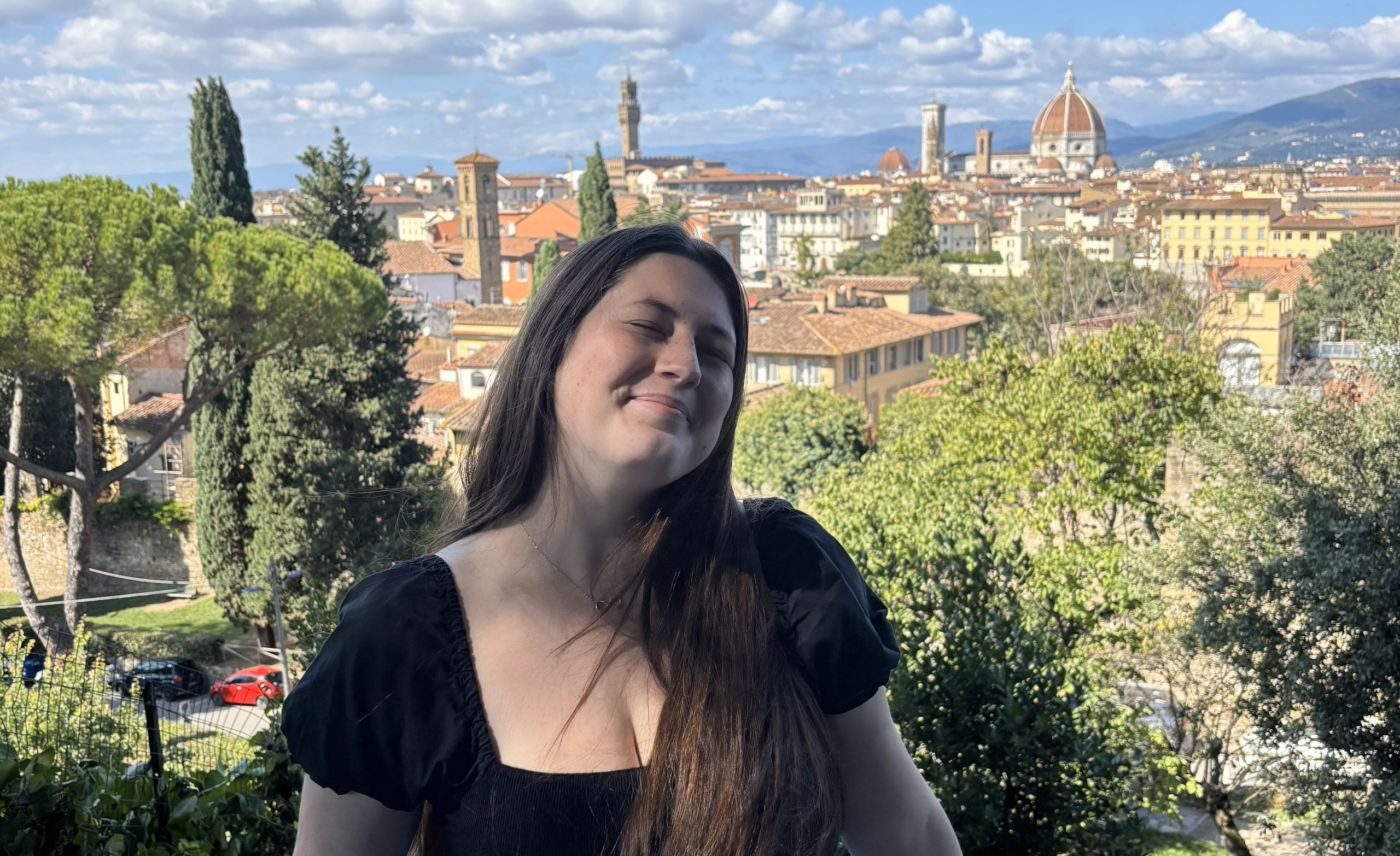 Sydney smiling with an Italian city behind her