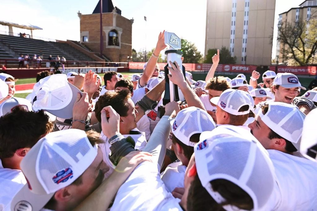 Men's lacrosse team holding up a trophy