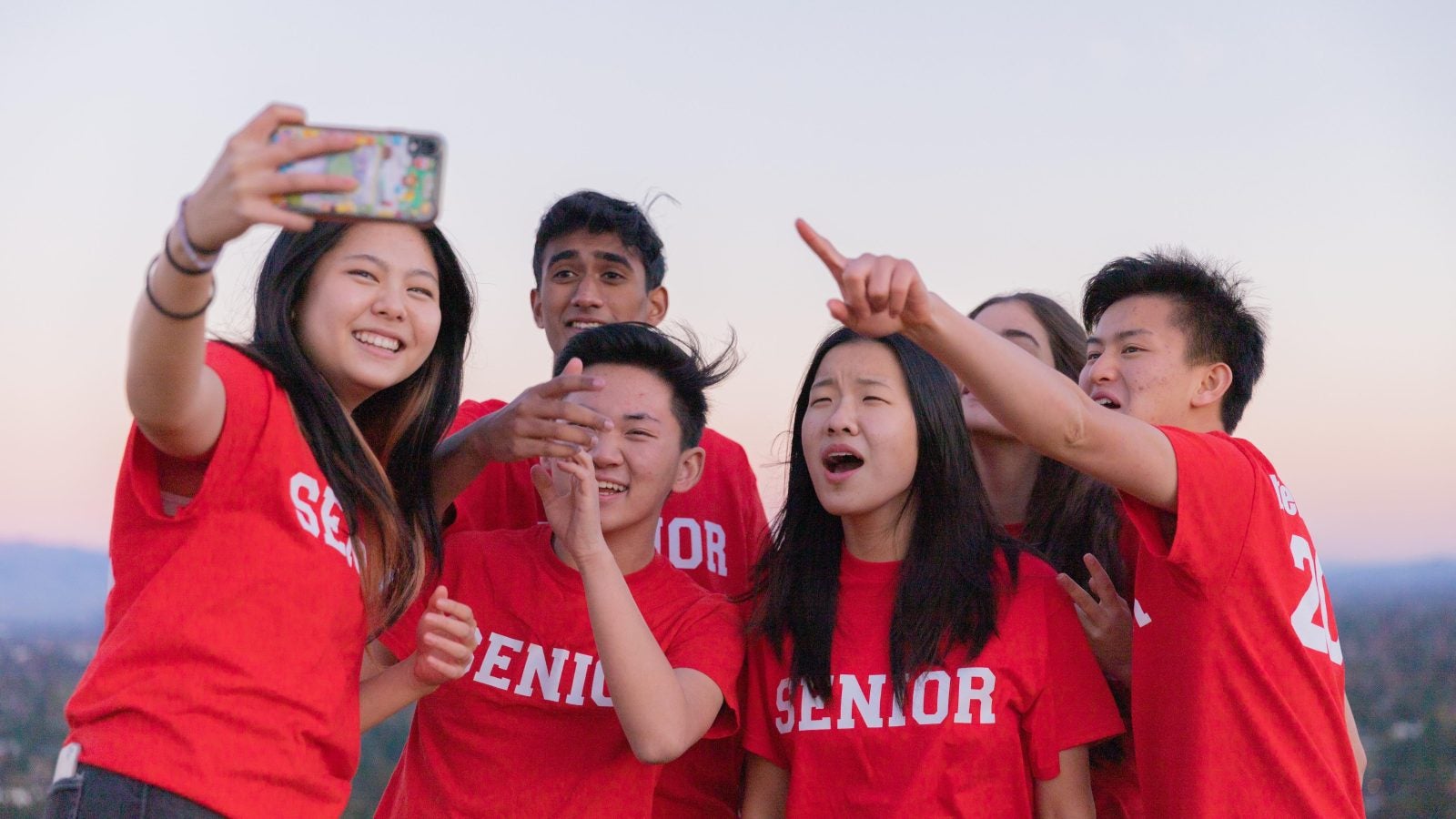 A group of students taking a selfie all while wearing red t shirts