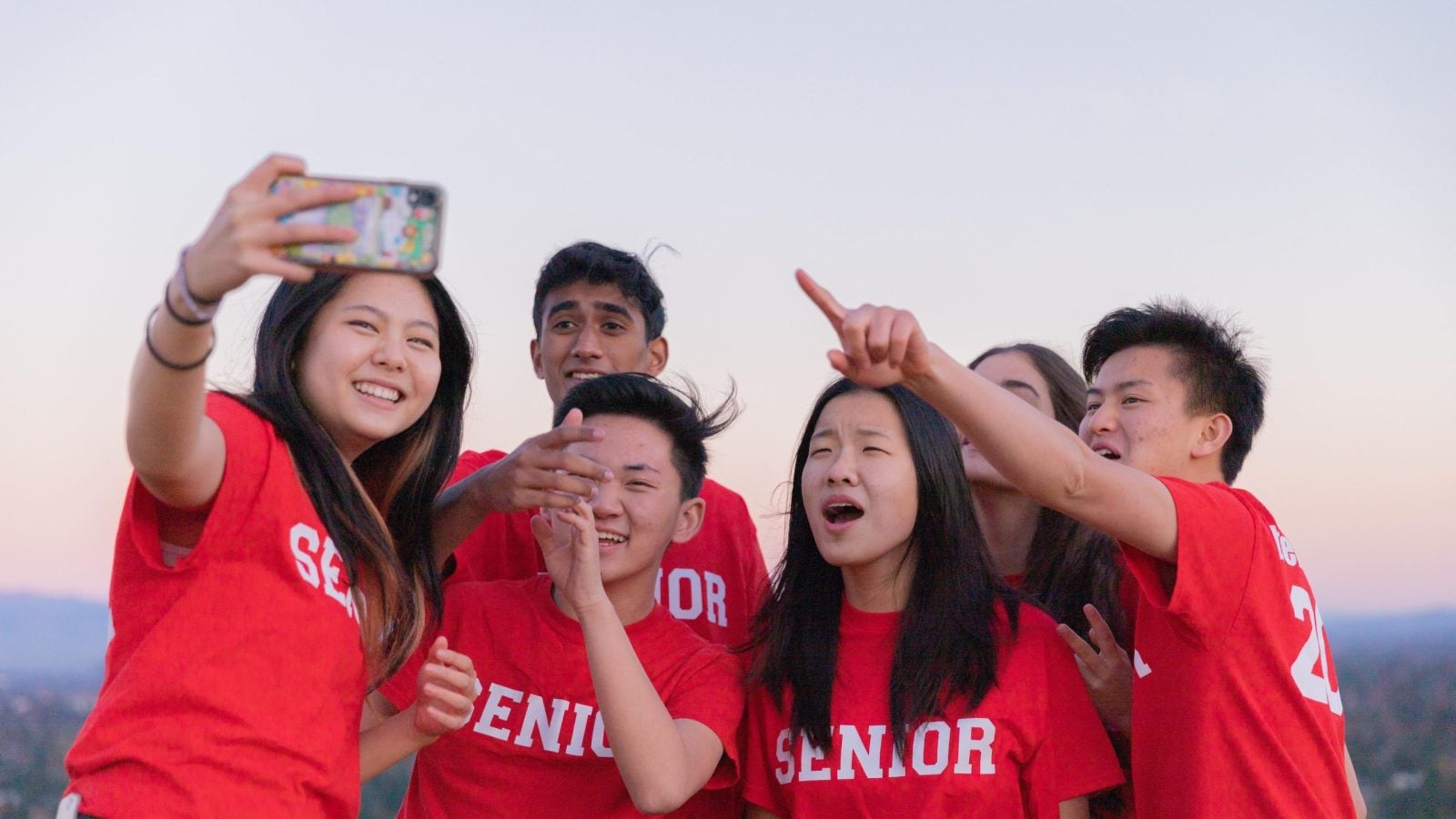 A group of students taking a selfie all while wearing red t shirts