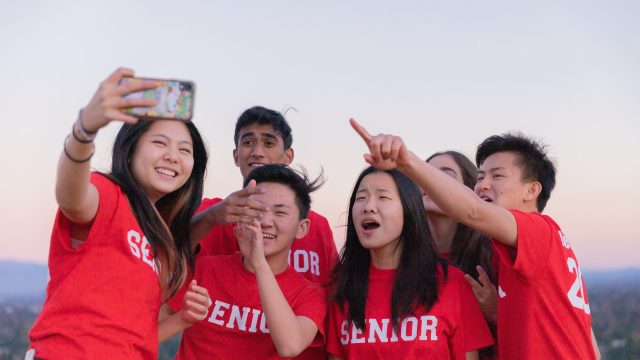 A group of students taking a selfie all while wearing red t shirts