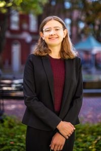 Young Caucasian woman with glasses wearing a black blazer