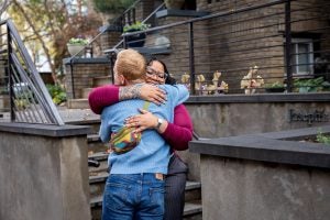 A Black woman embraces a Caucasian man