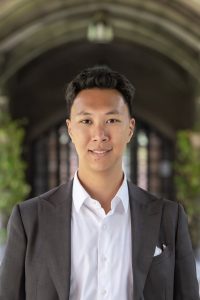 Young Asian man in a blazer and white shirt smiling
