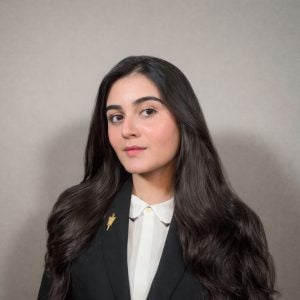 Young woman with a smirk with black hair in a suit