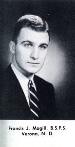 A black and white photo of a male student wearing a suit and tie in 1951.