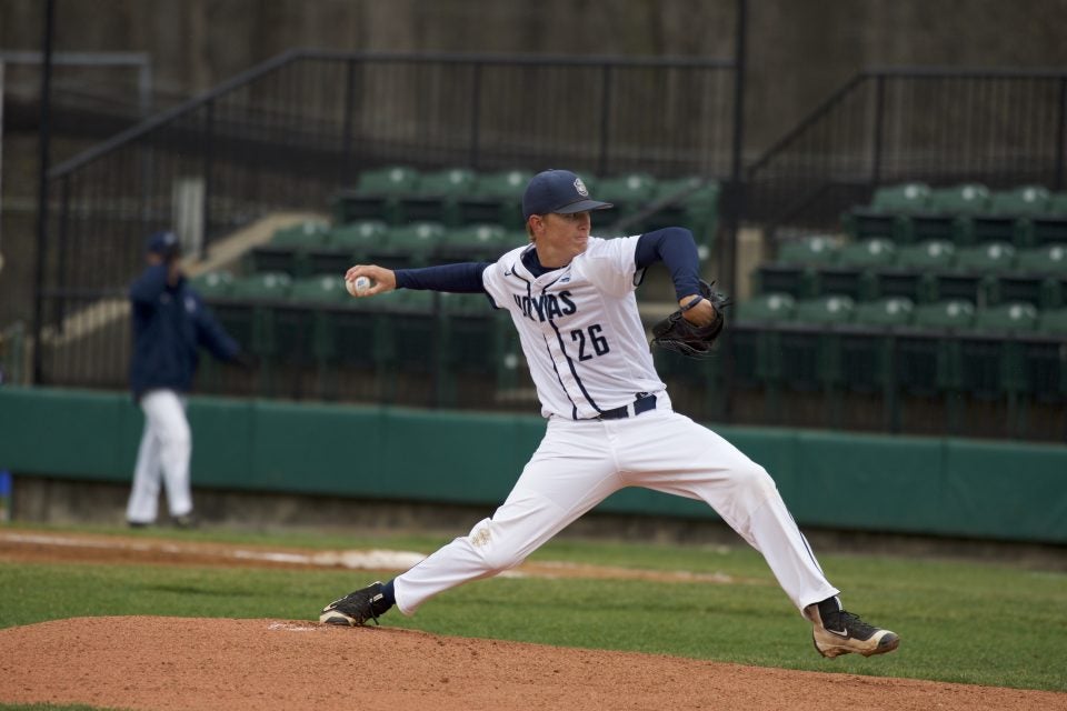 Young Caucasian man pitches a baseball in a Georgetown uniform