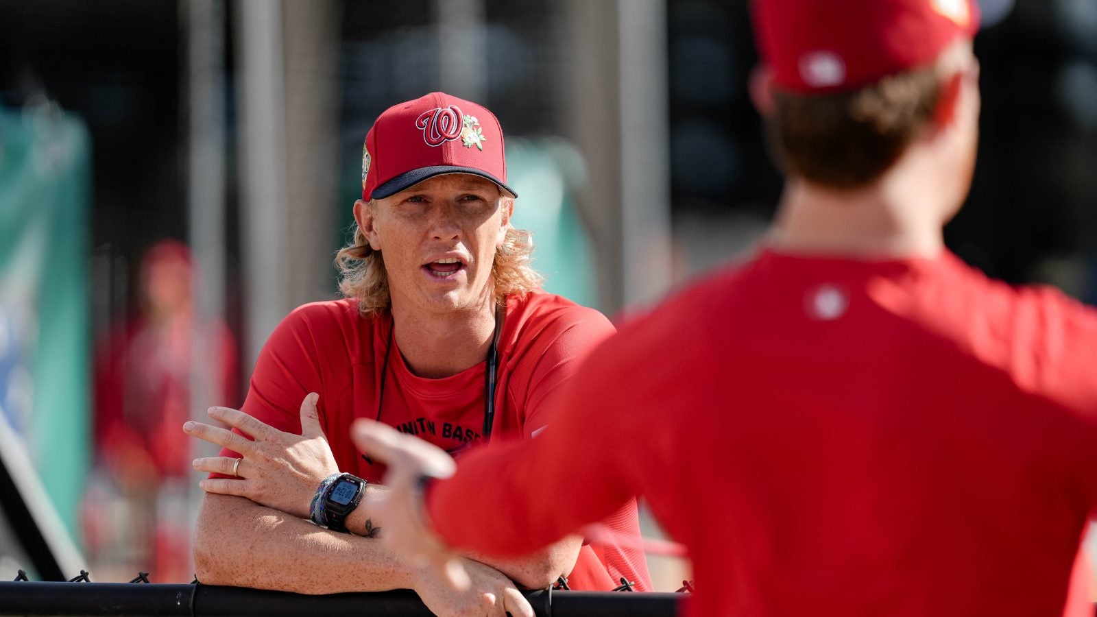 Young Caucasian man in Nats gear coaching players