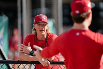 Young Caucasian man in Nats gear coaching players