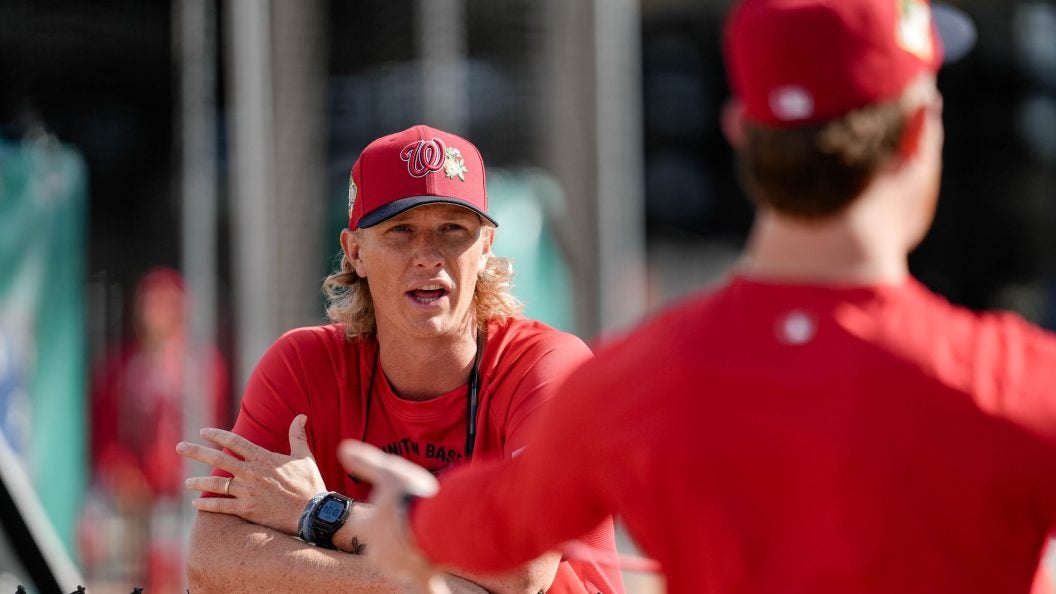 Young Caucasian man in Nats gear coaching players