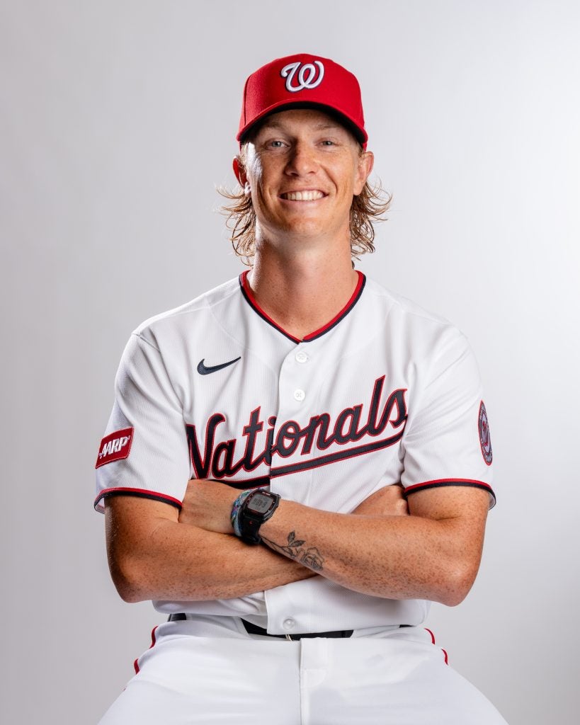 Young Caucasian man in a Nats uniform with arms crossed