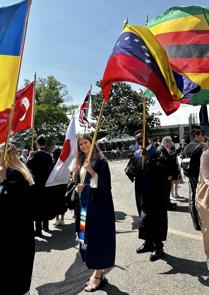 A student holds a flag during a graduation ceremony