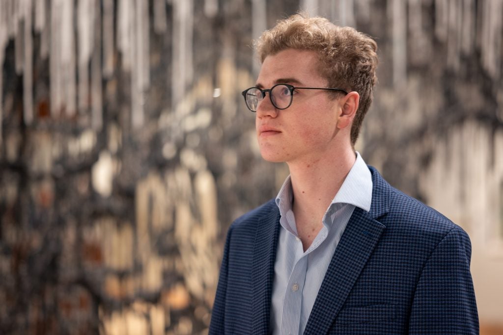 Young Caucasian man in a suit with glasses