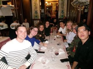 Group of students sit around a table in a restaurant