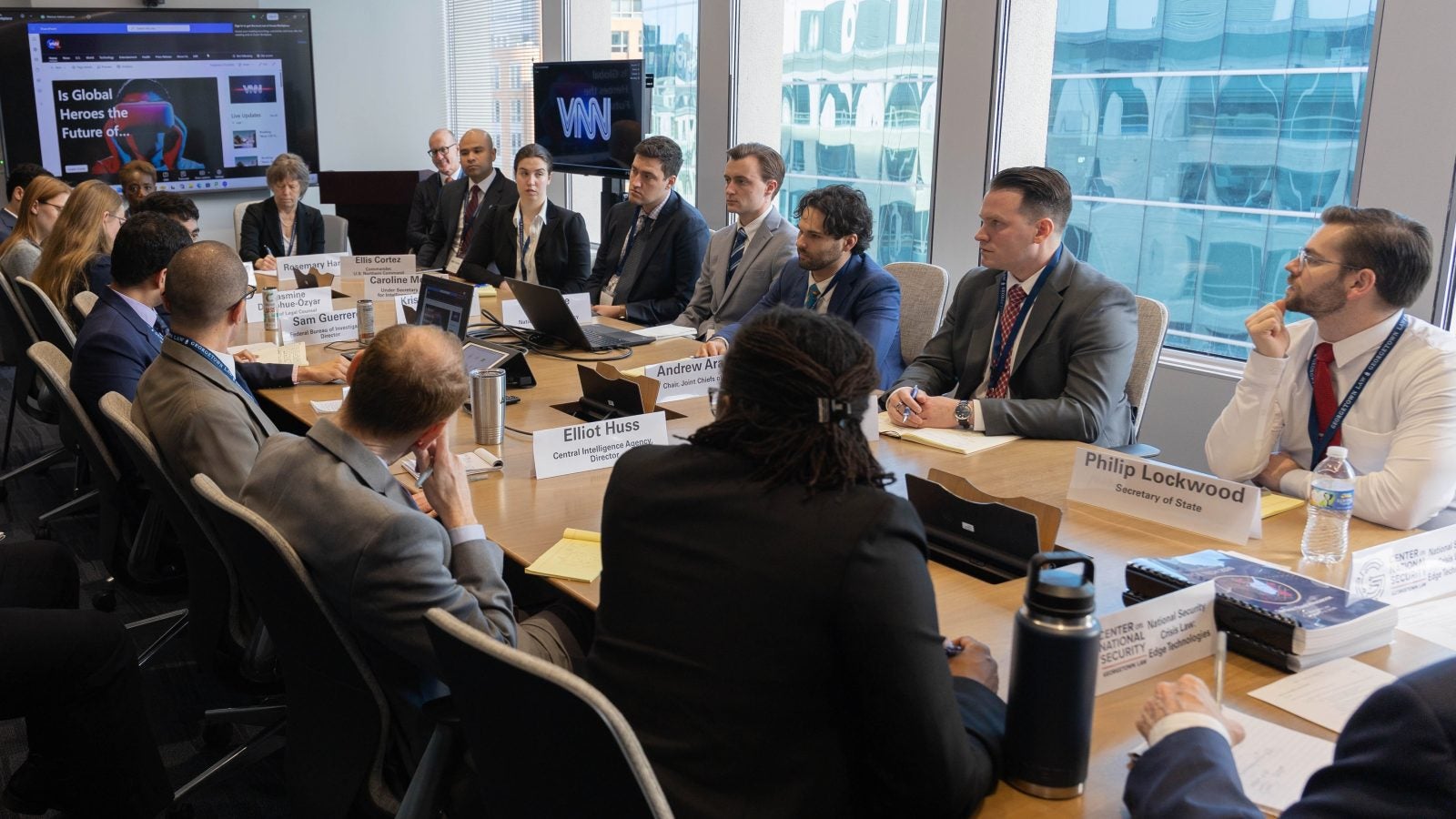 Law students sit around a conference room table wearing suits