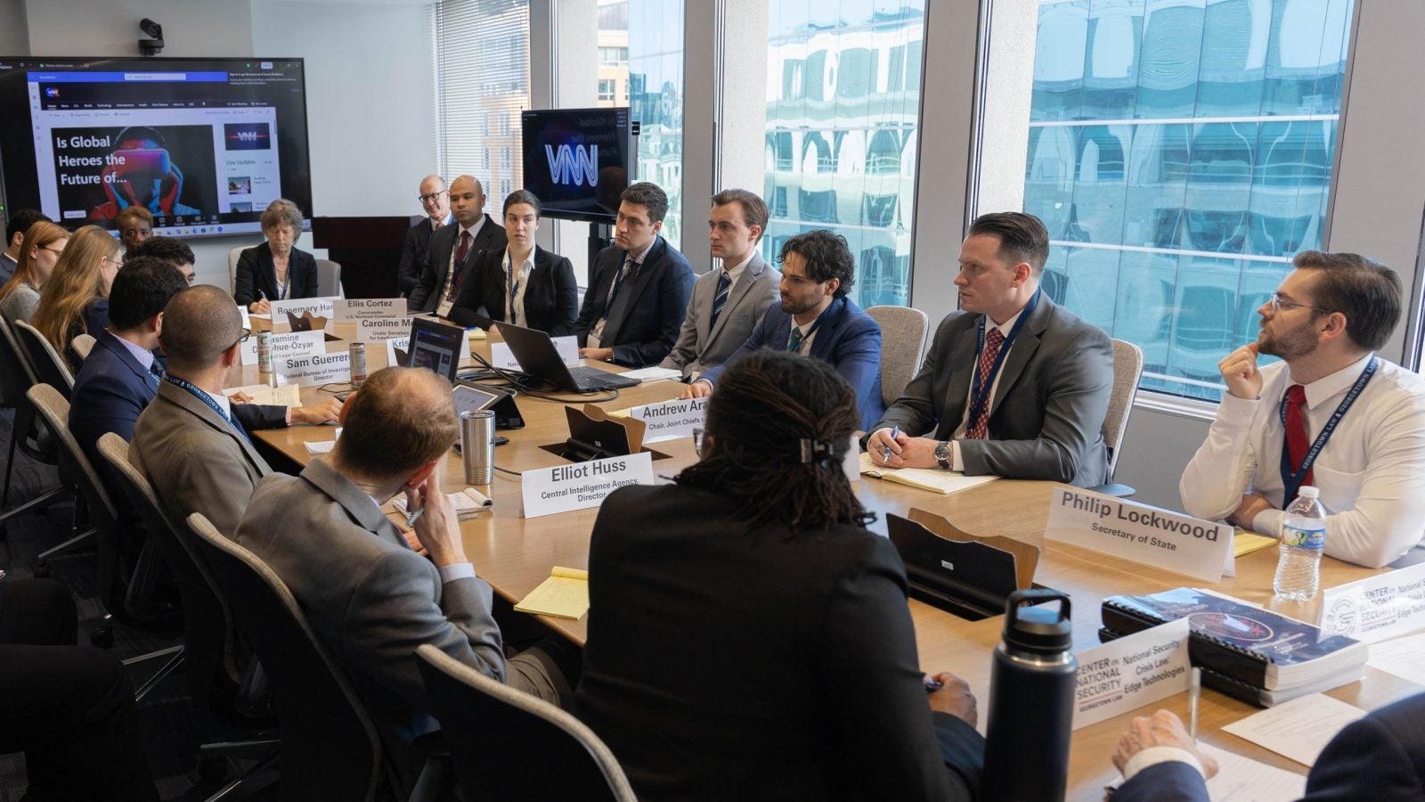 Law students sit around a conference room table wearing suits