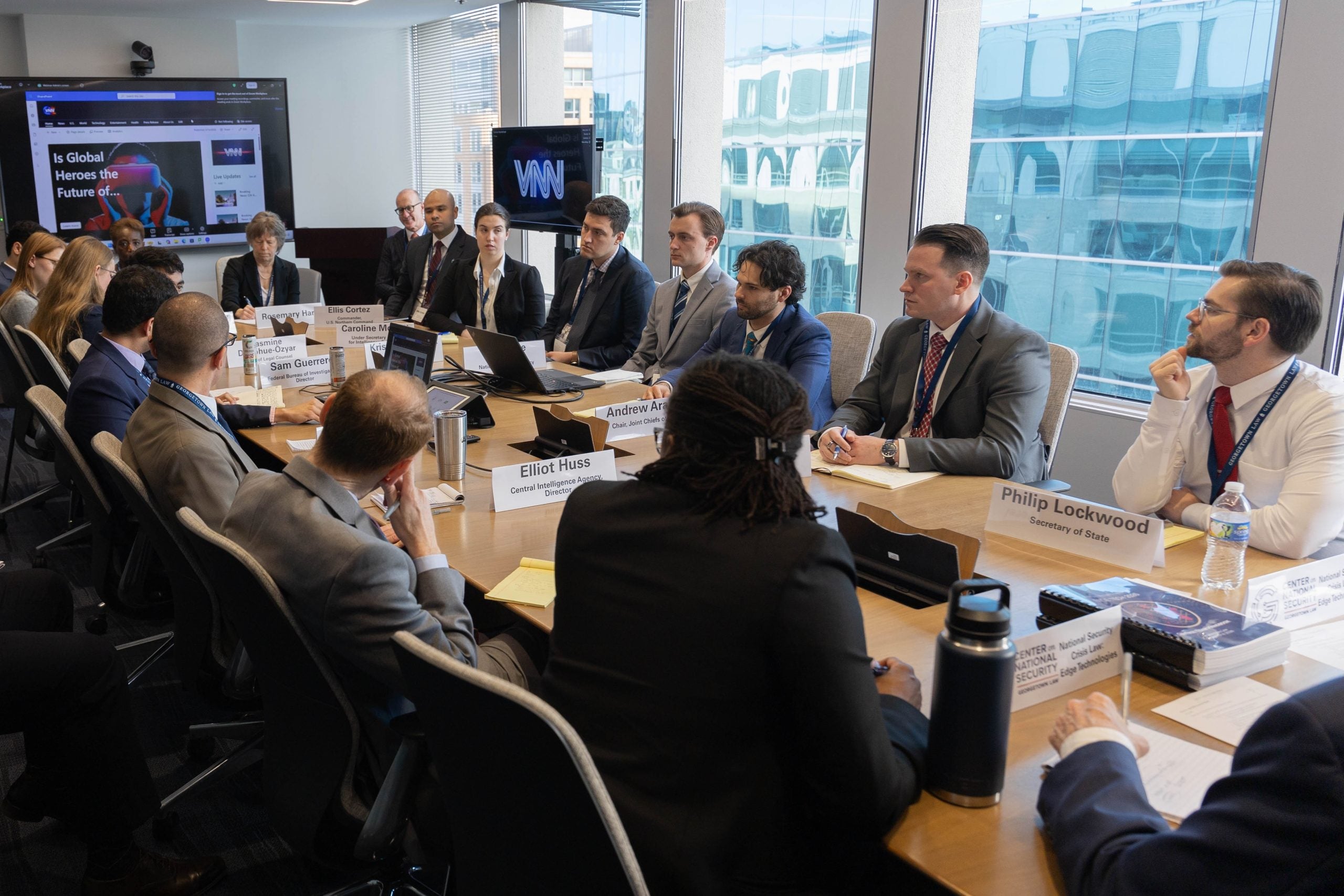 Law students sit around a conference room table wearing suits