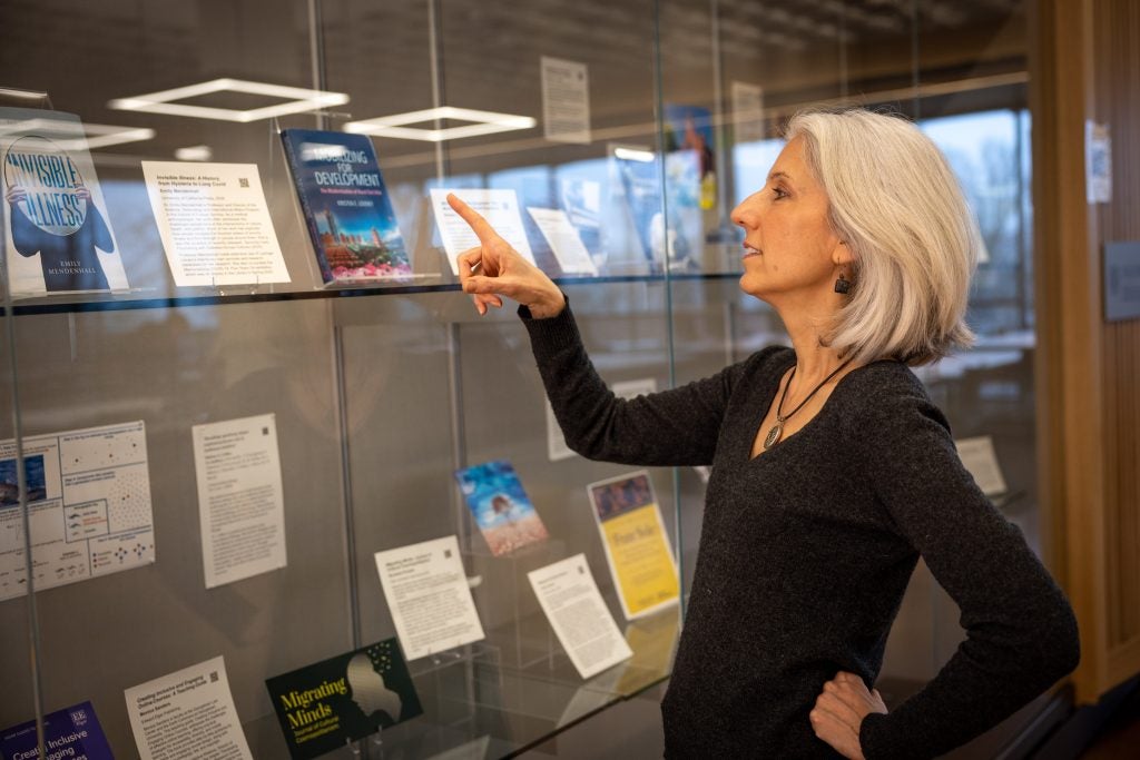 A woman points at an exhibit in a library