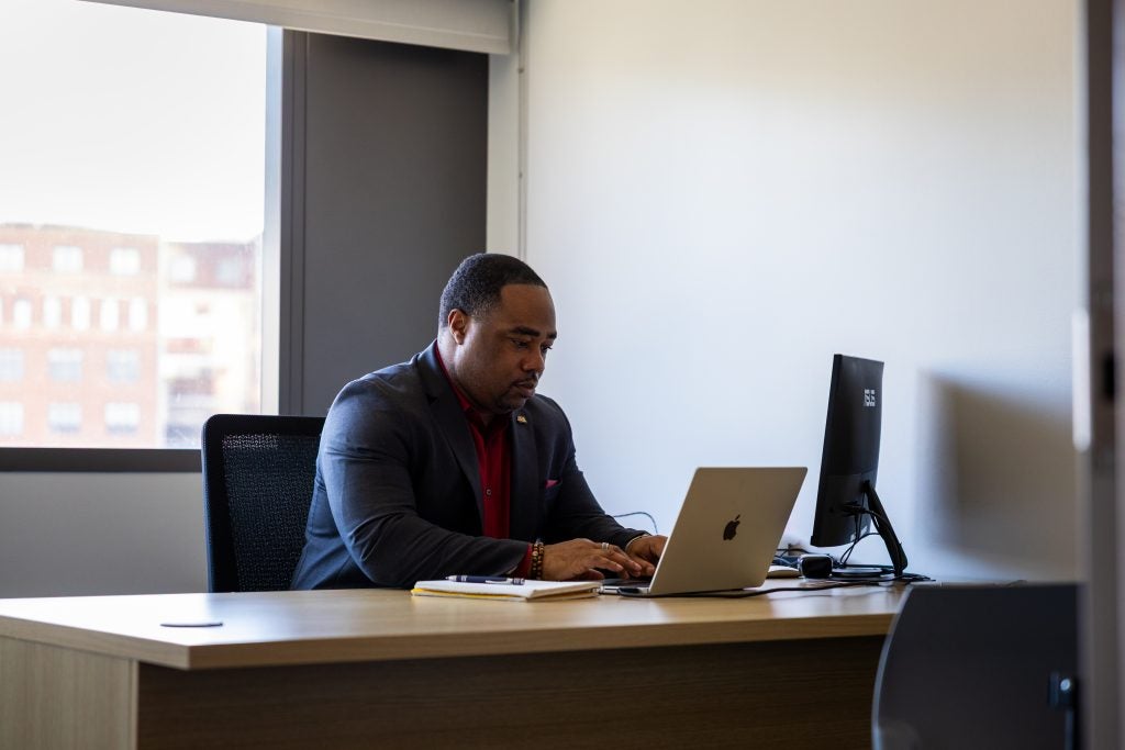 Black man in suit works at desk