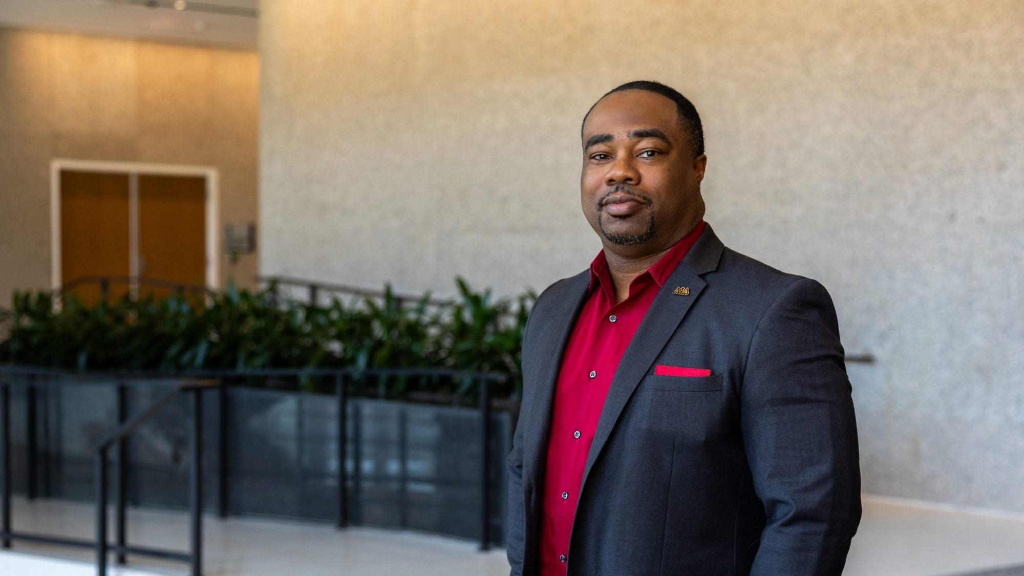 Black man in suit and red shirt