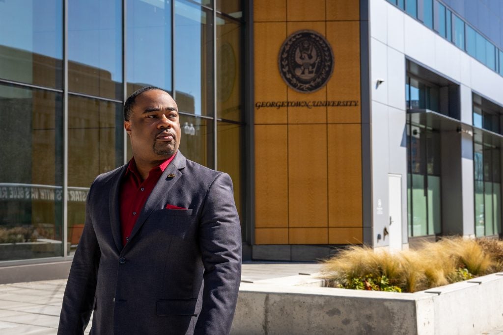 Black man in suit walks outside