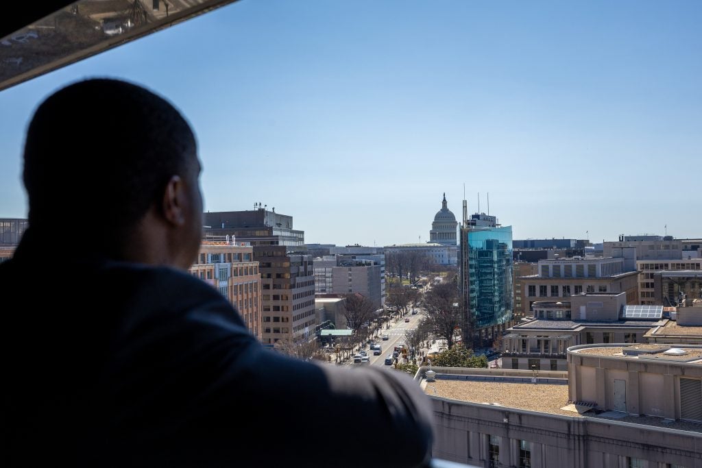 Black man looks at the Capitol skyline