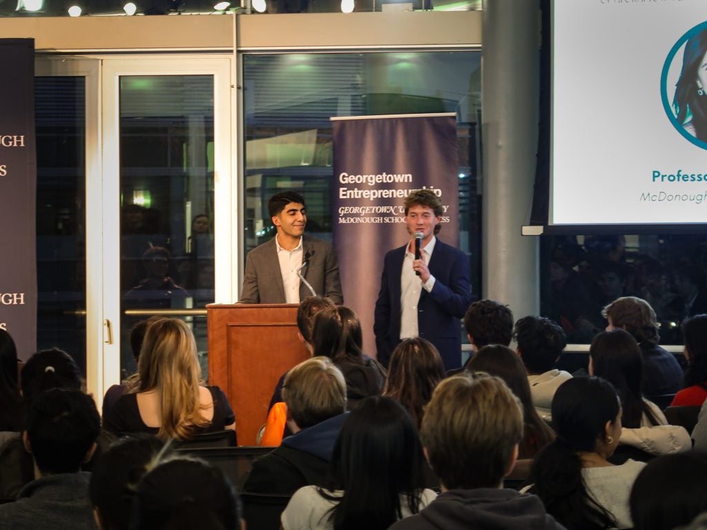 Two young men introducing a speaker onstage