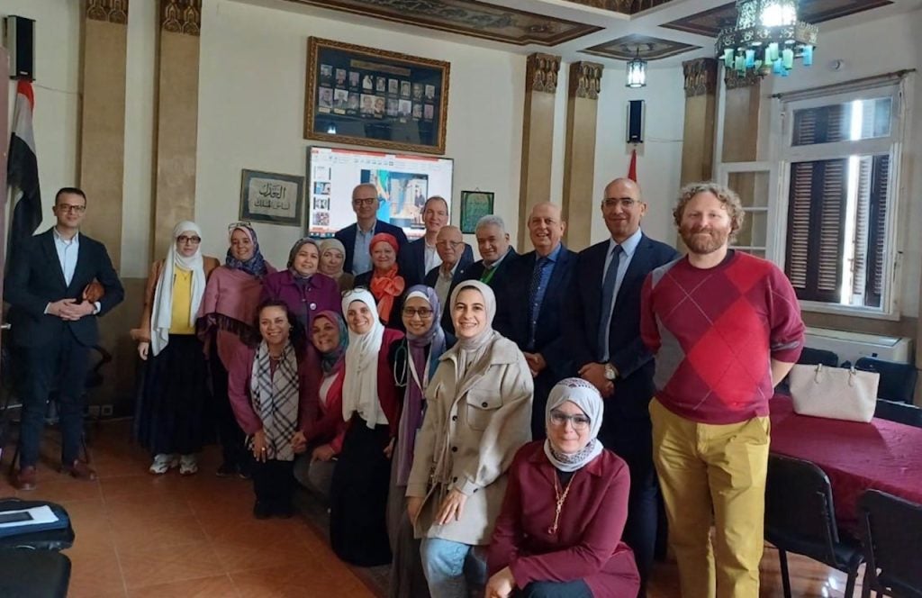 A group of men and women pose together in a room in Egypt