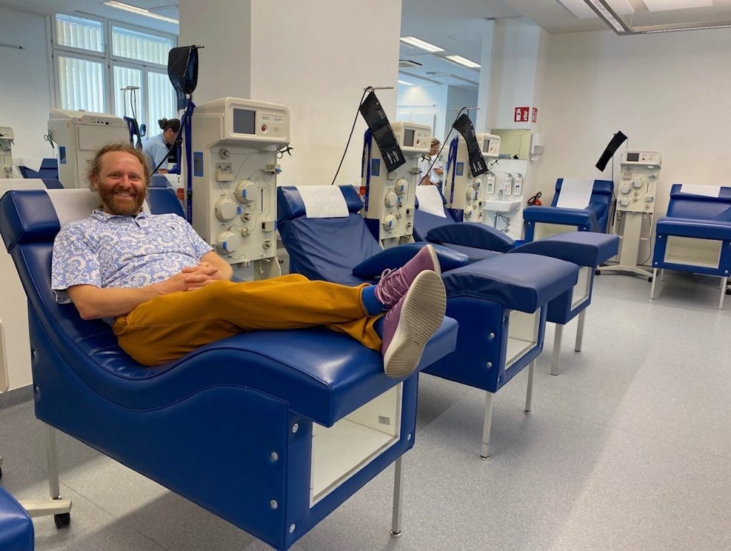 A man lays on a blue bed in a blood bank