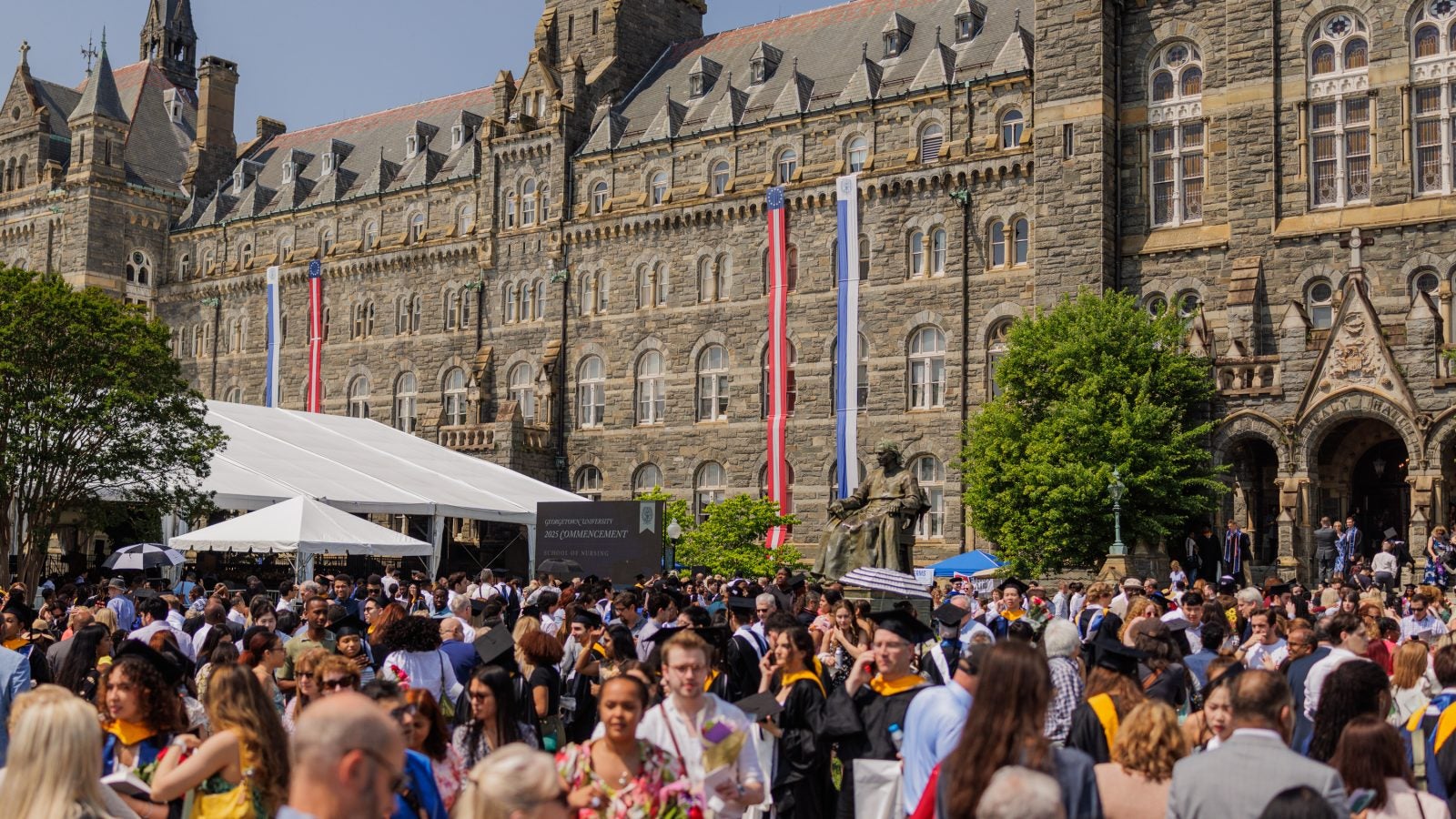 A crowd gathers in front of Healy Hall during commencement