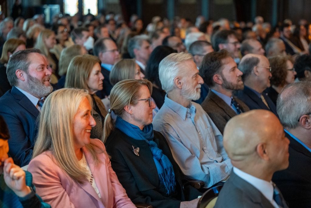 Audience members smile while listening to a speech