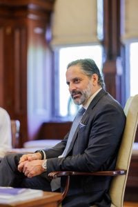 President-elect Eduardo Peñalver listens while sitting in a chair in his office
