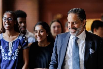 President-elect Eduardo Peñalver smiles while talking to a group of students in a hallway