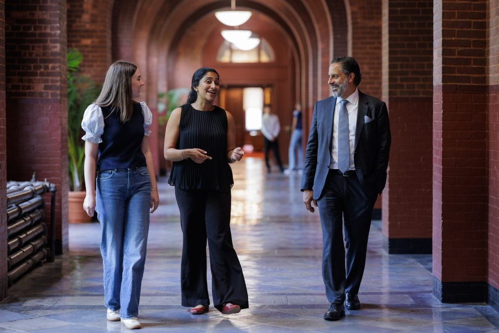 President-elect Eduardo Peñalver talks to two students in a hallway at Georgetown