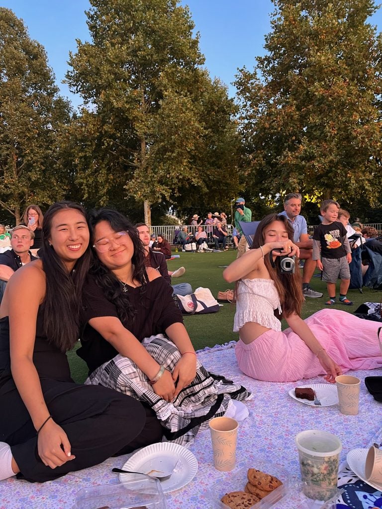 Three young women on a picnic blanket on a warm day