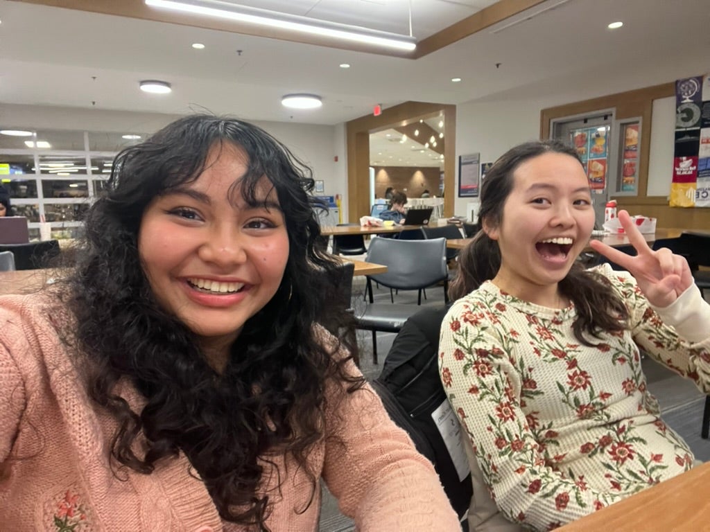 Two students in a library setting