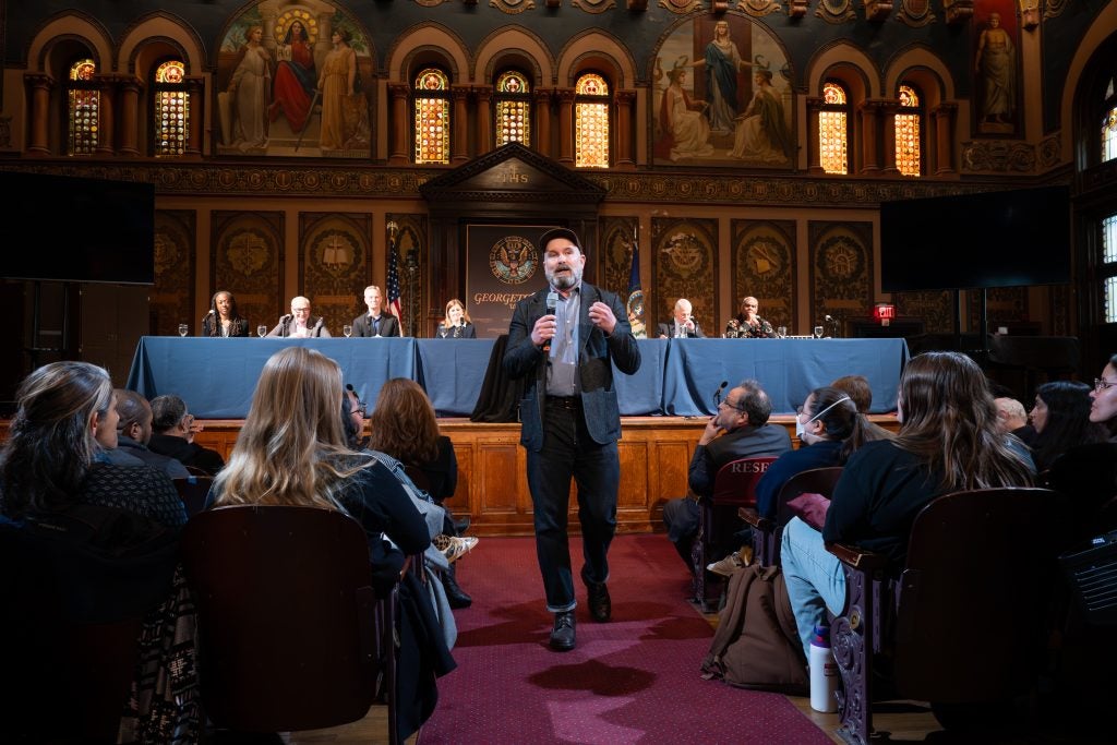Man walks down center aisle in Gaston Hall during event
