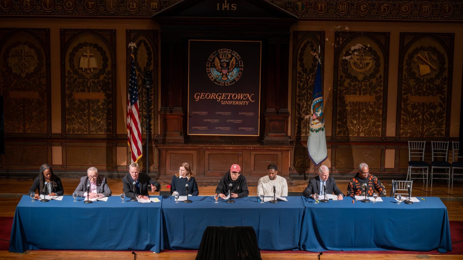 A panel on stage in Gaston Hall during performance
