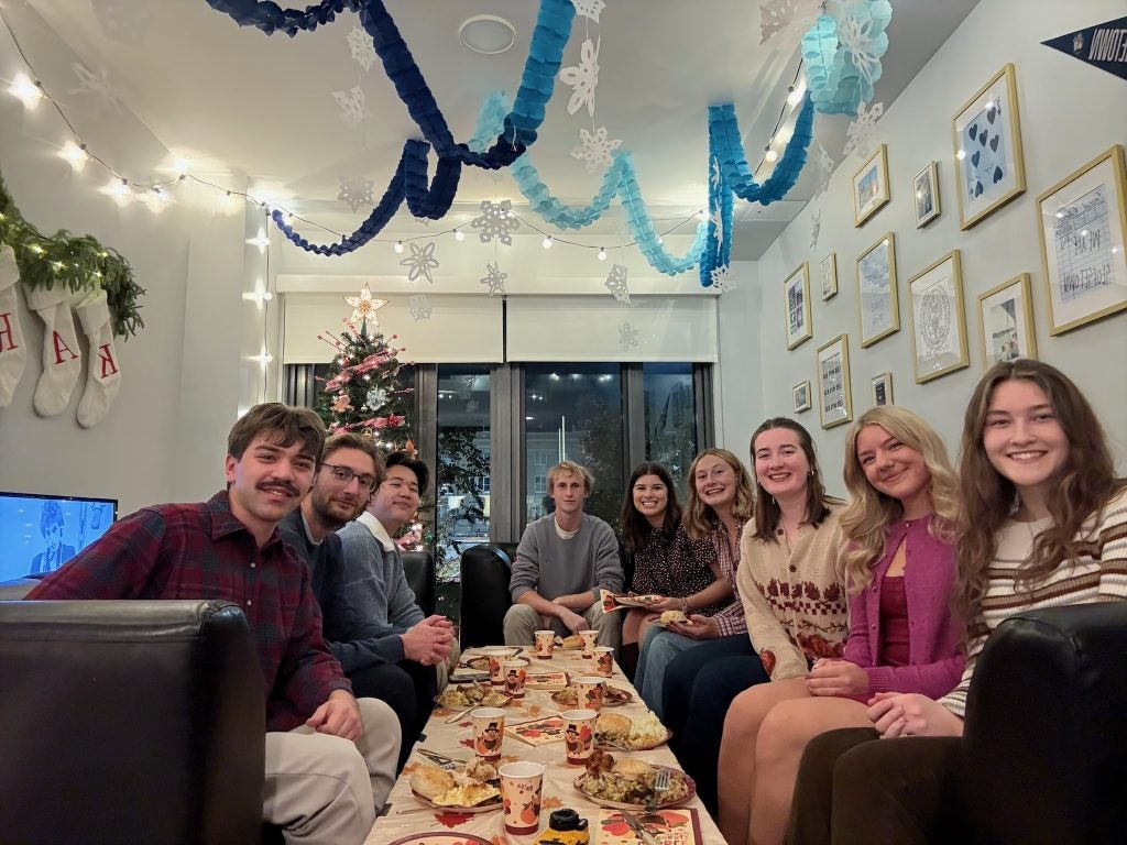 A group of students in an apartment sharing a meal