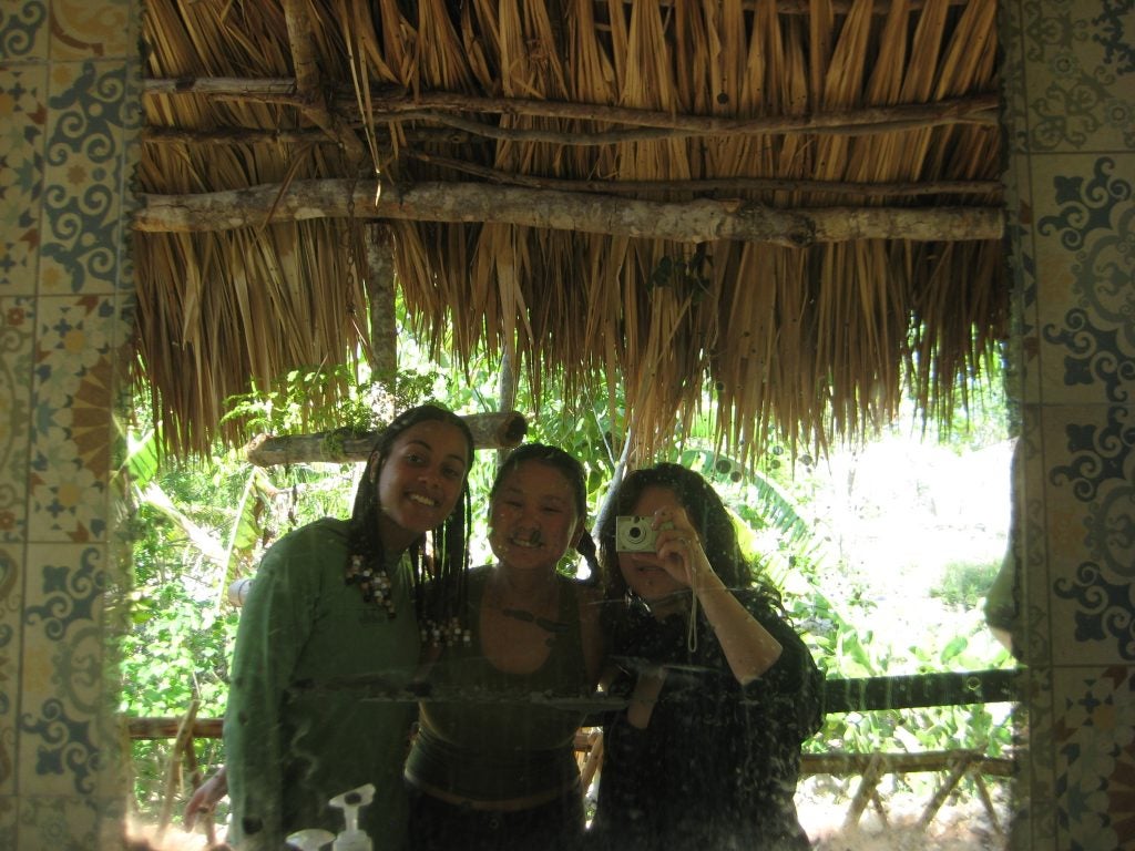 Three young women in a mirror in a tropical setting