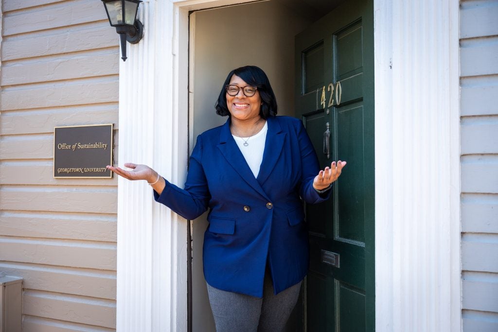 Smiling Black woman in a blue suit standing in a doorway